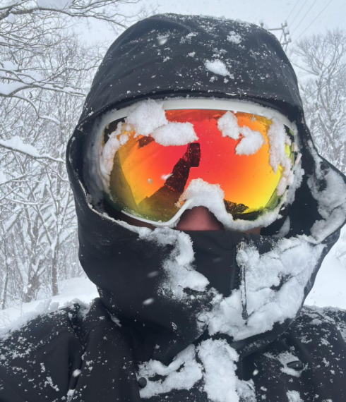 Una compañera cubierta de nieve con gafas de esquí de espejo.